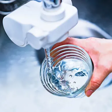 Hand holding glass under faucet